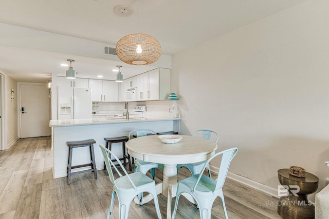 dining area featuring sink and light hardwood / wood-style flooring