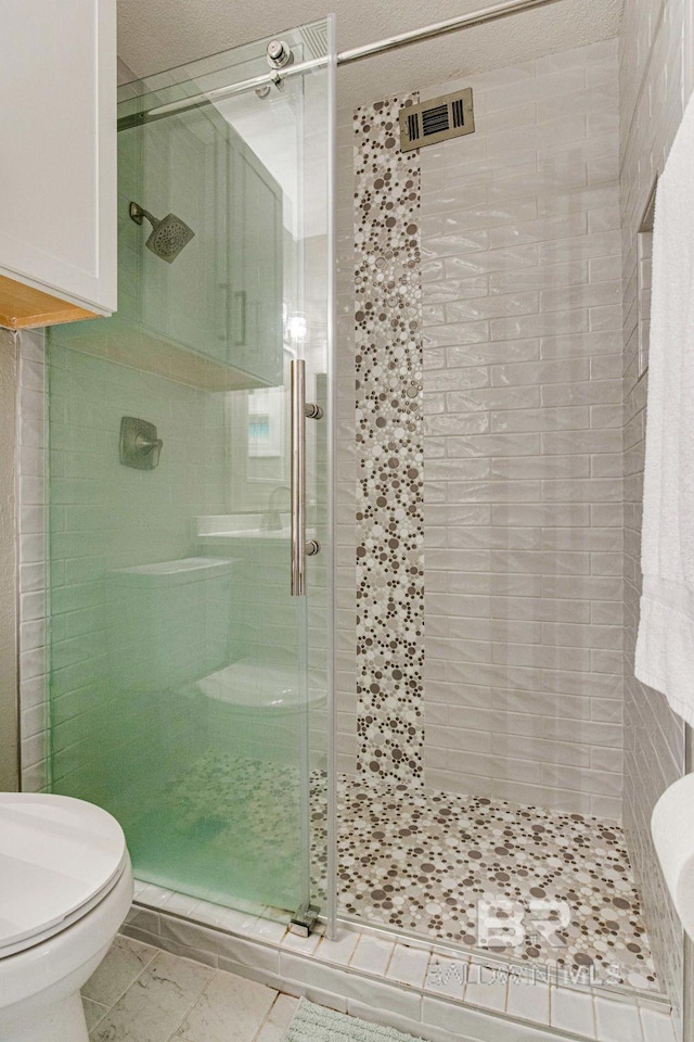 bathroom featuring an enclosed shower and toilet