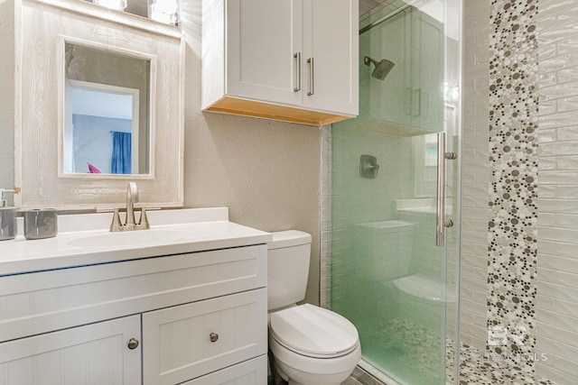 bathroom with vanity, walk in shower, and toilet