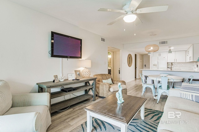 living room featuring ceiling fan and light wood-type flooring