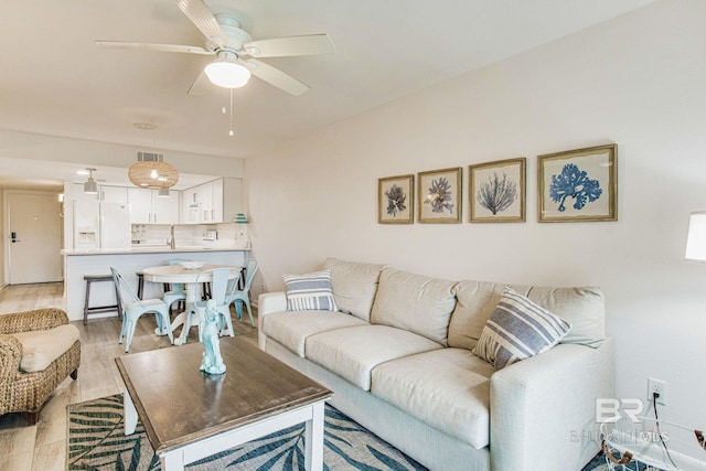 living room with light hardwood / wood-style floors and ceiling fan