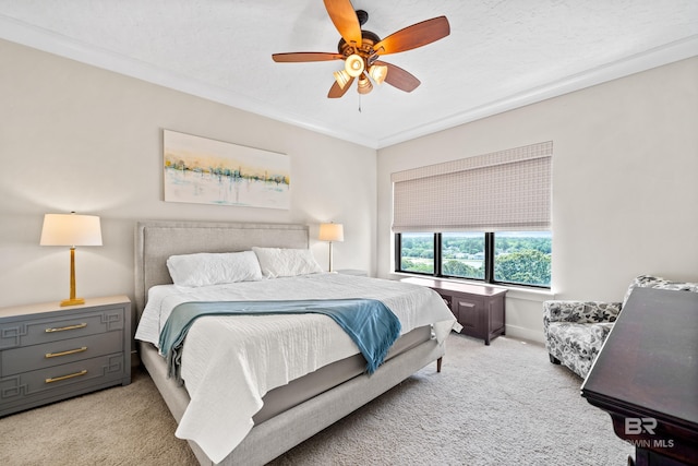 bedroom featuring ornamental molding, ceiling fan, and light carpet