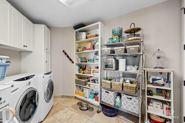 laundry area featuring baseboards, cabinet space, and washer and clothes dryer