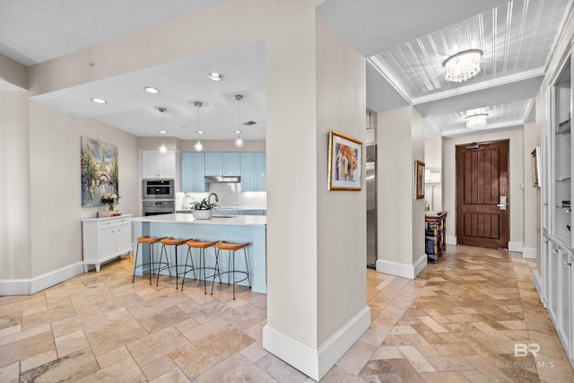 foyer featuring baseboards, stone tile floors, a notable chandelier, and recessed lighting
