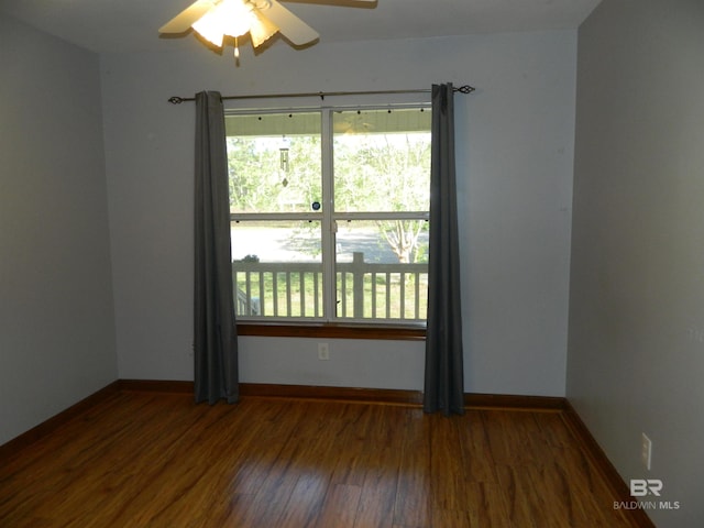 empty room with dark hardwood / wood-style flooring and ceiling fan