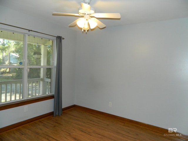 unfurnished room featuring dark wood-type flooring and ceiling fan