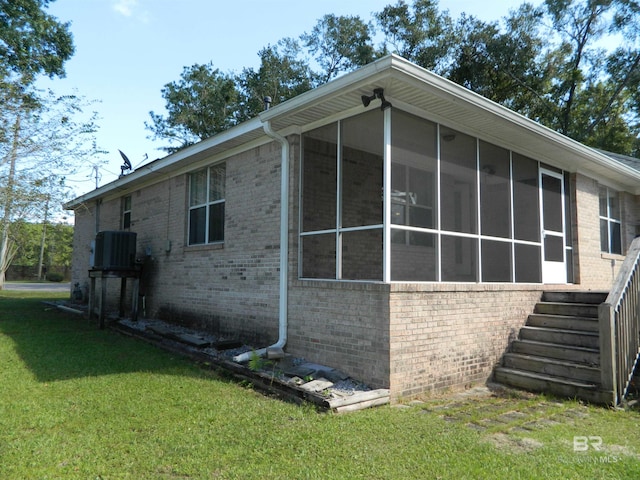 view of home's exterior featuring a yard, a sunroom, and cooling unit