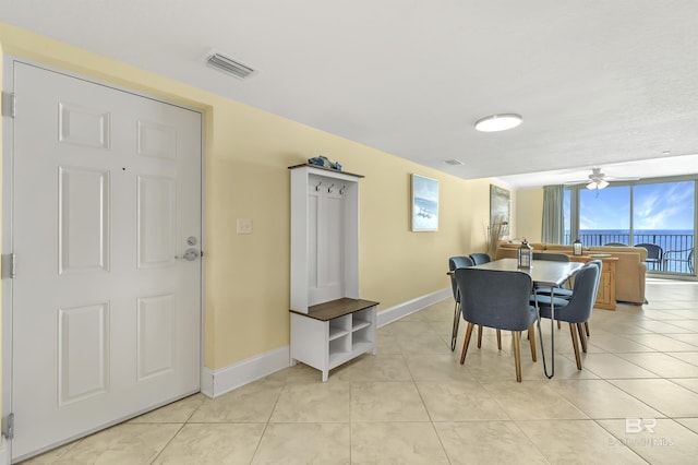 dining space featuring ceiling fan, light tile patterned flooring, visible vents, and baseboards