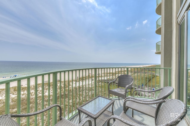 balcony with a water view and a view of the beach