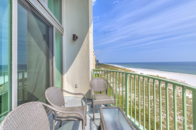 balcony featuring a beach view and a water view