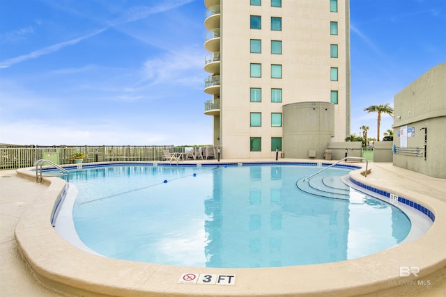 community pool featuring fence and a patio