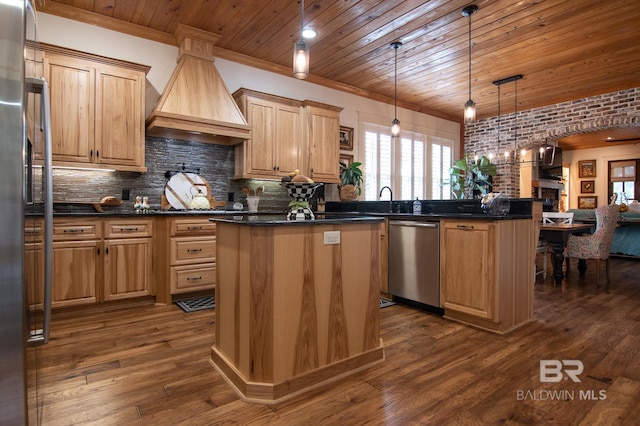 kitchen featuring appliances with stainless steel finishes, custom range hood, decorative light fixtures, a kitchen island, and dark wood-type flooring