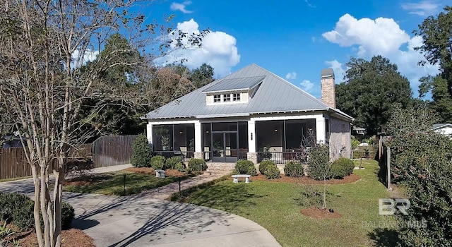 view of front of property with a sunroom and a front lawn