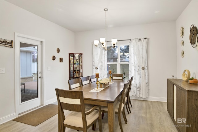 dining room featuring a notable chandelier and light wood-type flooring