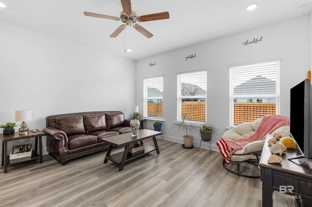 living area with recessed lighting, light wood-style flooring, a ceiling fan, and baseboards