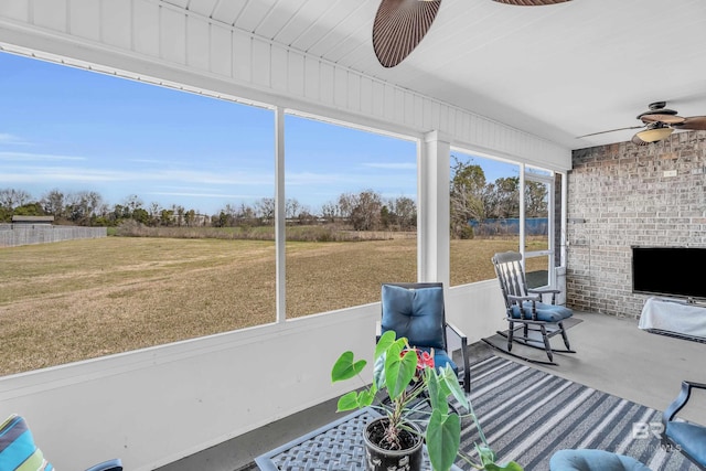 unfurnished sunroom with ceiling fan