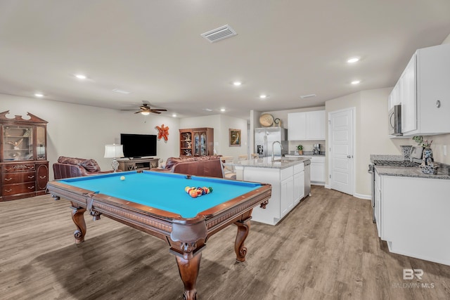 rec room with light wood-style flooring, a sink, visible vents, and recessed lighting