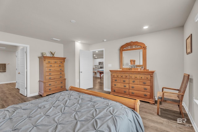 bedroom with recessed lighting, baseboards, and light wood finished floors