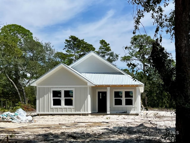 modern farmhouse style home with metal roof and board and batten siding