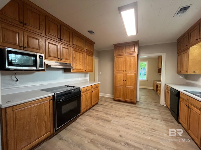 kitchen with under cabinet range hood, visible vents, decorative backsplash, and black appliances