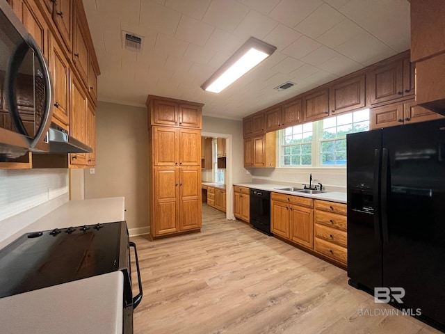 kitchen with crown molding, black appliances, a sink, and visible vents