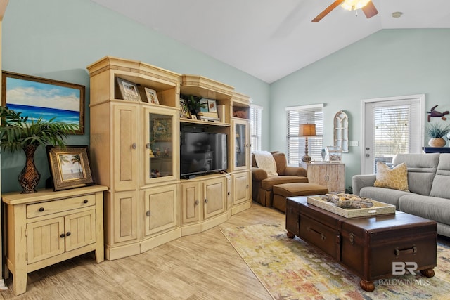 living room featuring ceiling fan, lofted ceiling, and light wood-type flooring