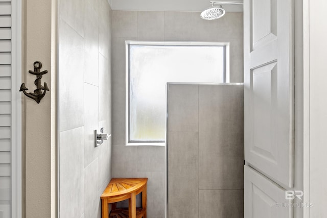 bathroom featuring a shower and tile walls