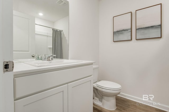 bathroom featuring vanity, hardwood / wood-style floors, a shower with shower curtain, and toilet