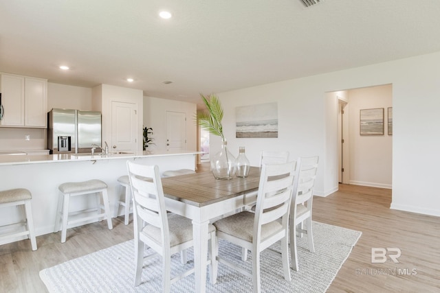 dining area featuring light hardwood / wood-style floors and sink