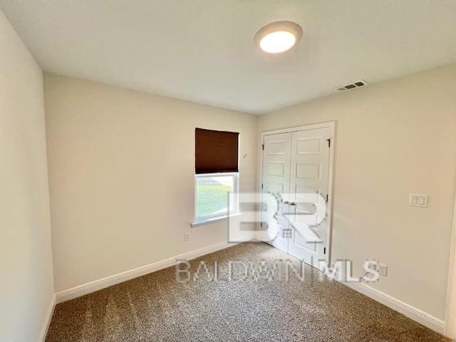 unfurnished bedroom featuring carpet and a closet