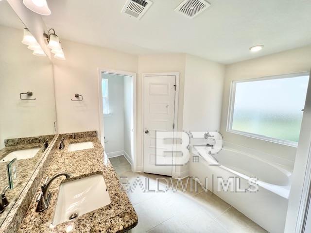 bathroom featuring tile patterned floors, a tub to relax in, and vanity