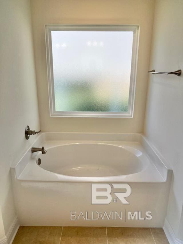 bathroom with a tub to relax in, tile patterned floors, and plenty of natural light