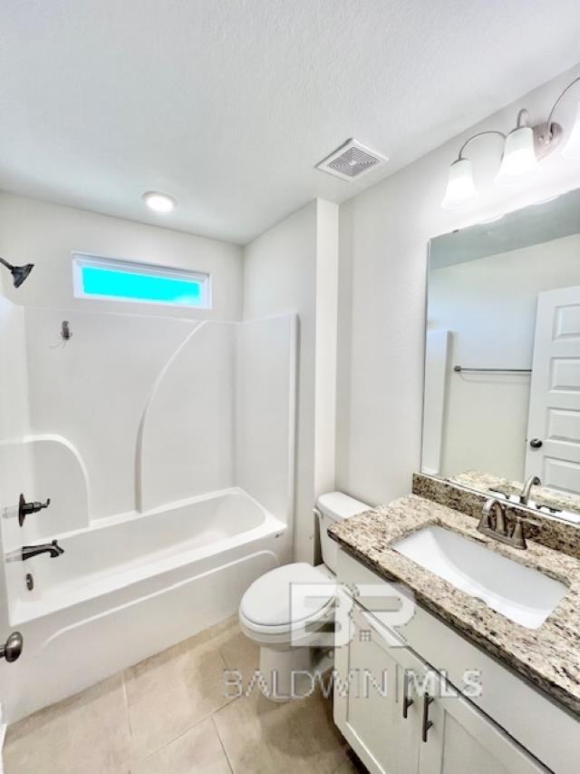 full bathroom featuring vanity, tile patterned flooring, toilet, a textured ceiling, and shower / bath combination