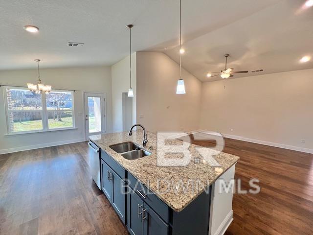 kitchen with a center island with sink, dishwasher, sink, and hanging light fixtures