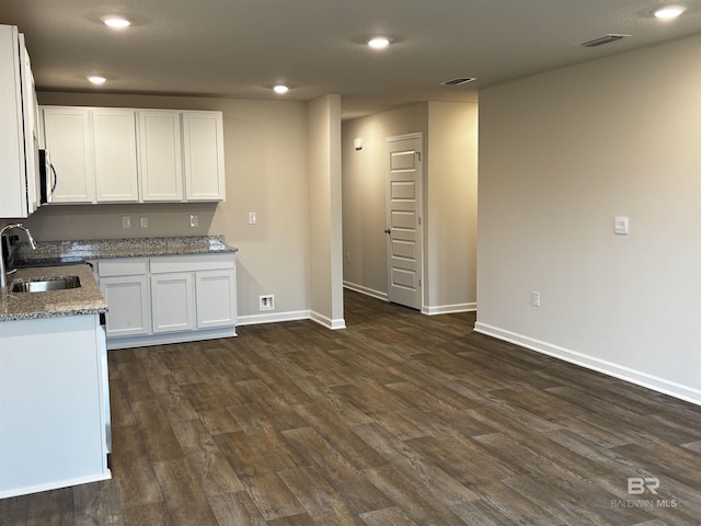 13710 Logan Pl, Foley, AL 36535 - kitchen featuring a sink, dark wood-style flooring, white cabinets, baseboards, and light stone counters