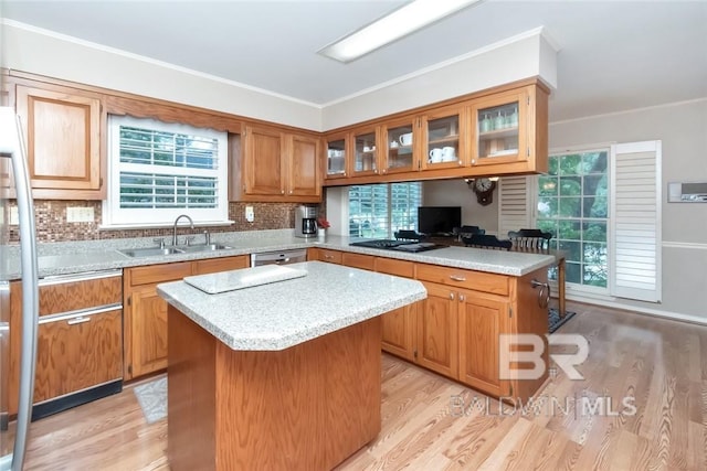 kitchen featuring a kitchen island, light hardwood / wood-style floors, sink, and backsplash