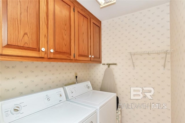 laundry room with washing machine and clothes dryer and cabinets