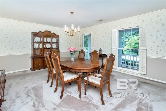 dining space with carpet, a chandelier, and ornamental molding