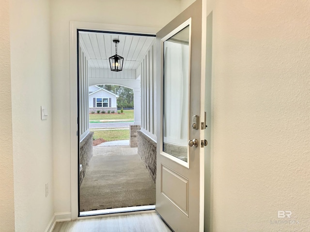 entryway featuring a textured wall, baseboards, and wood finished floors