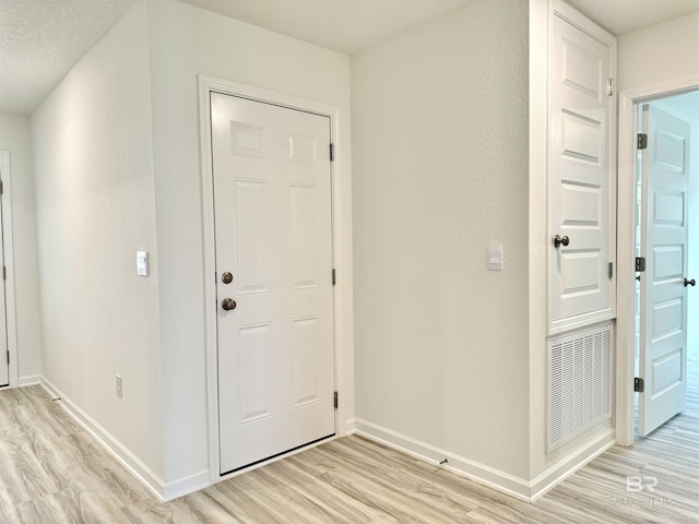 entrance foyer featuring light wood-type flooring and baseboards