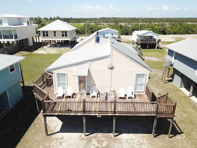 rear view of house featuring a wooden deck and a yard