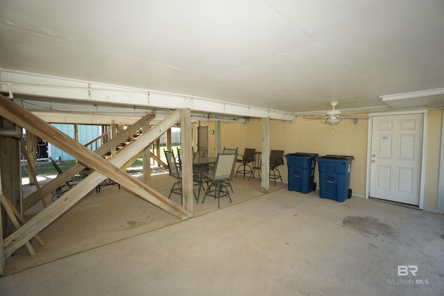 basement featuring a ceiling fan and stairs