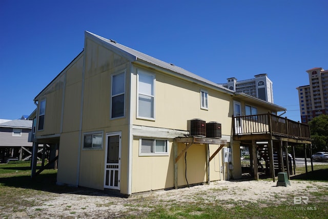 rear view of house with a wooden deck, stairway, and central AC