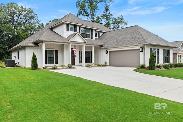 view of front facade featuring a garage, central AC, and a front yard