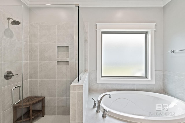 bathroom with tile walls, shower with separate bathtub, and ornamental molding