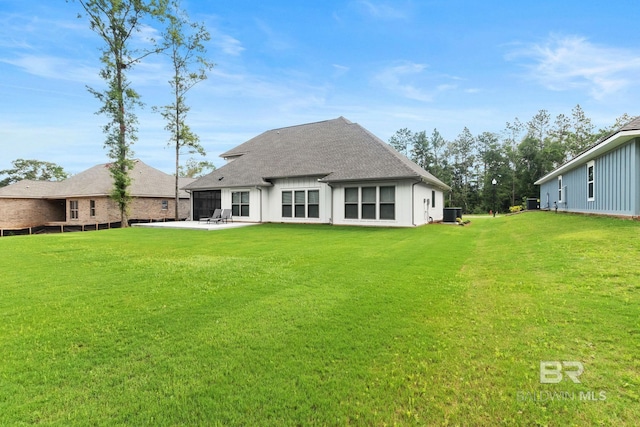 rear view of property with a patio and a lawn