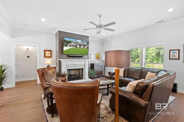 living room featuring light hardwood / wood-style floors, ornamental molding, and ceiling fan