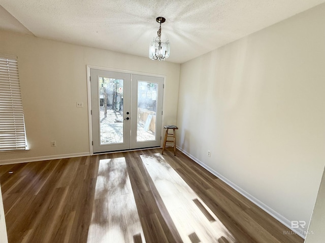 doorway featuring hardwood / wood-style flooring, french doors, a textured ceiling, and an inviting chandelier