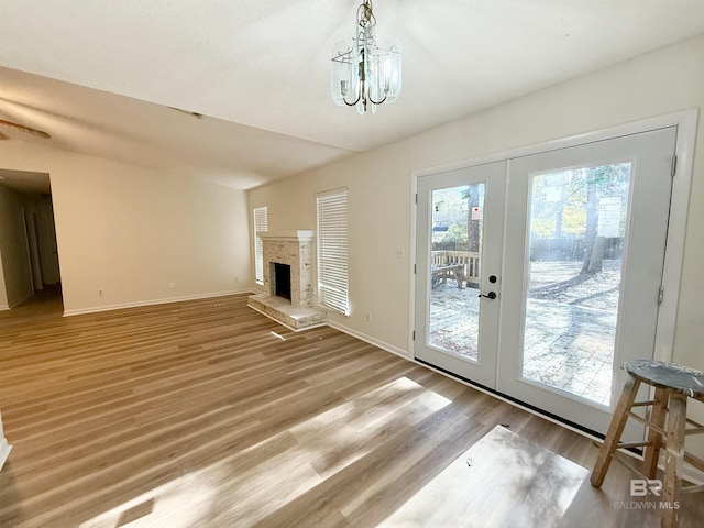 unfurnished living room with hardwood / wood-style floors, french doors, and a chandelier