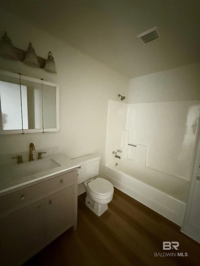 full bathroom with vanity, wood-type flooring,  shower combination, and toilet